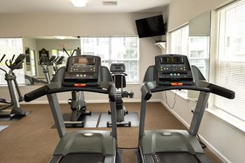 A gym with treadmills and elliptical machines.